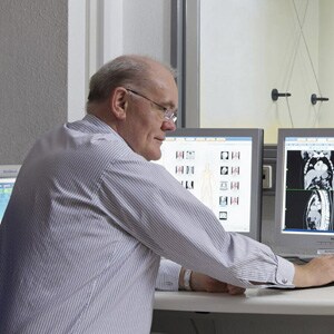 ein Mann sitzt an einem Schreibtisch und benutzt einen Computer
