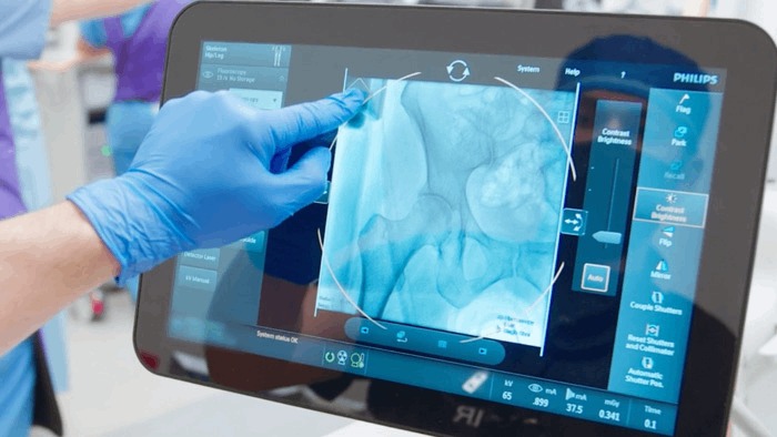 Chirurg, der während der Operation den Touchscreen bedient.