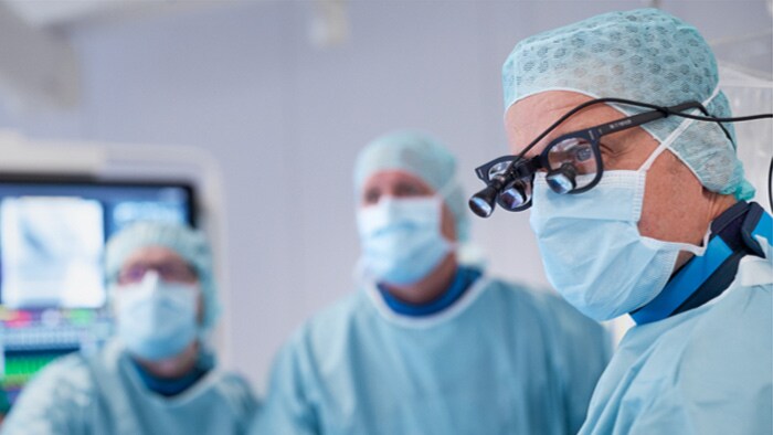 Ein Chirurg schaut während eines Eingriffs auf einen Monitor
