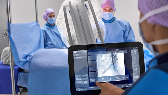 Orthopädischer Chirurg, der während des Eingriffs den Touchscreen bedient.