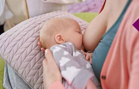 eine Frau, die ein Baby stillt