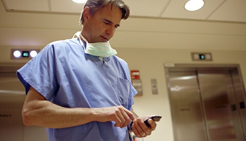 Un clinicien consulte des dossiers patient sur un appareil portable