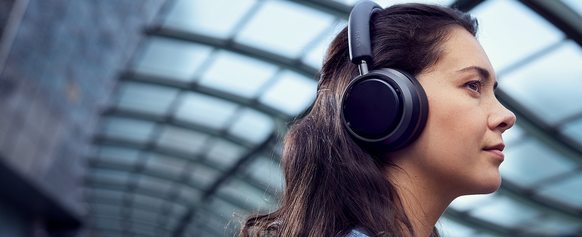  Frau genießt auf Reisen Musik mit Philips L4-Kopfhörern