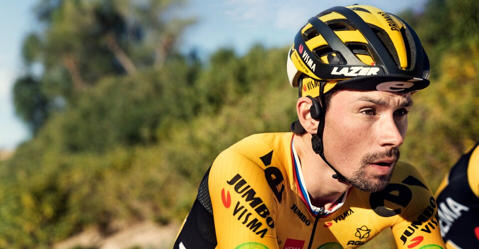CYCLIST WEARING BONE PHONES WITH A HELMET ON>