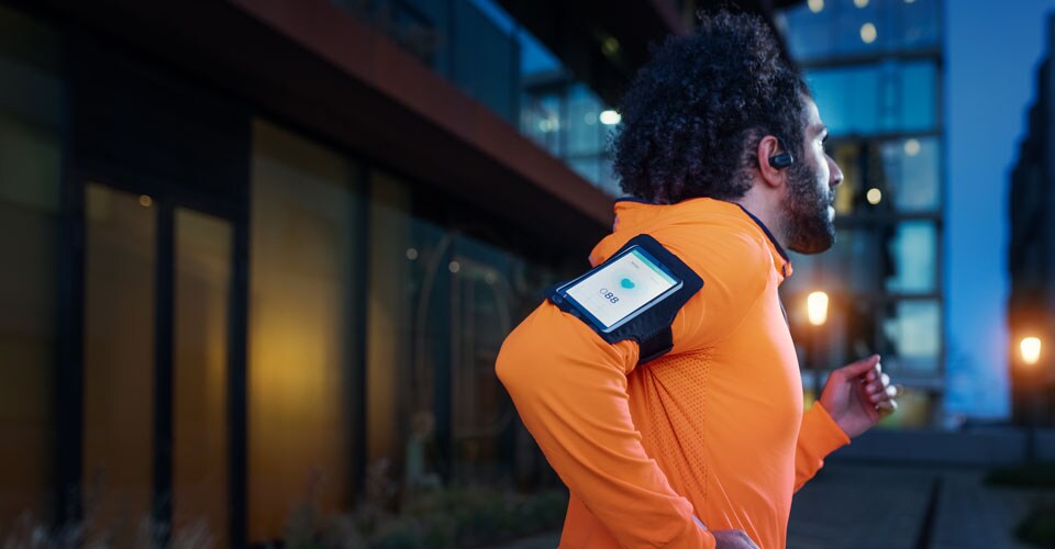 A man running outside with bone conduction headphones