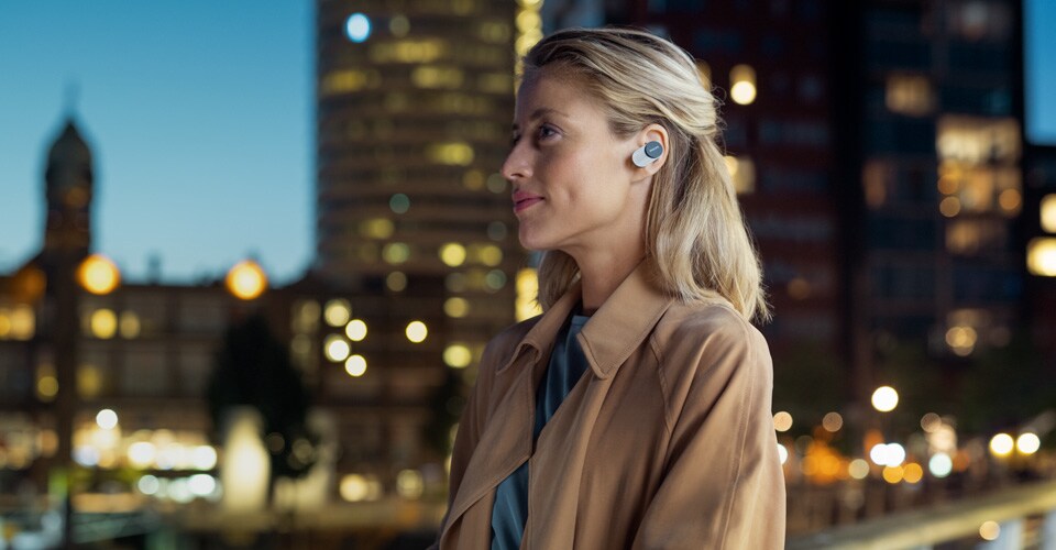 Une femme portant des écouteurs intra-auriculaires antibruit Philips en ville