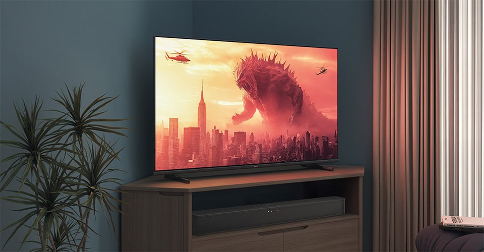 Un téléviseur Philips sur un support d'angle affiche un film Godzilla
