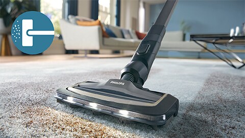 Der kabellose Philips AquaTrio Nass- und Trockensauger 9000 Series reinigt einen Teppich und einen Läufer