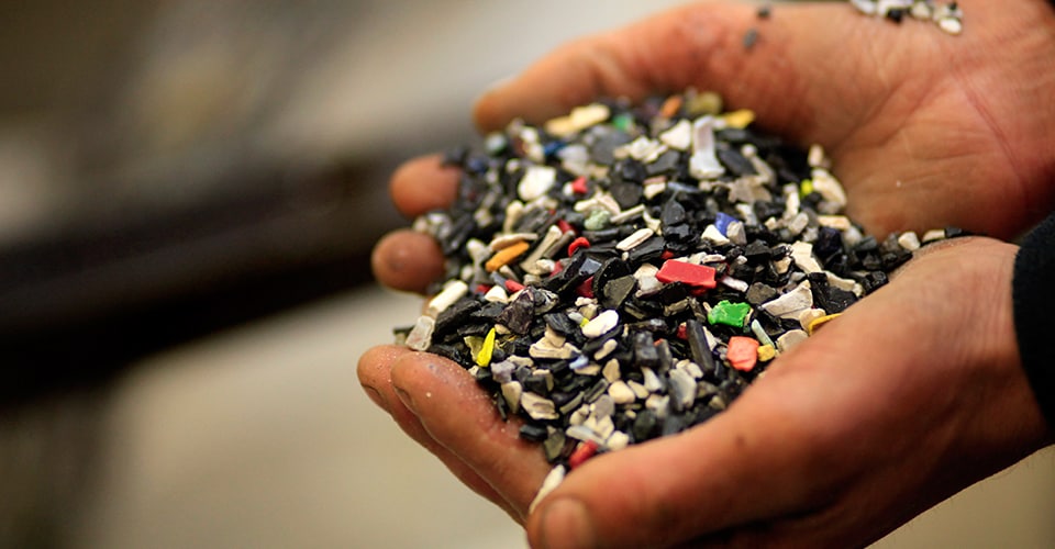 A close up of hands cupping broken pieces of material 